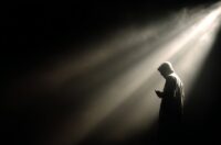 Image of a phone scammer standing in the shadows.